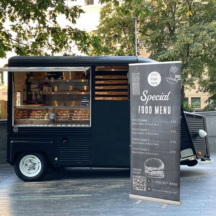 Modern Black Food Truck with Inviting Menu Banner Enhances Outdoor Dining Experience