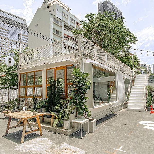 Modern Cafe Design Blending Glass, Metal, and Greenery for an Inviting Atmosphere