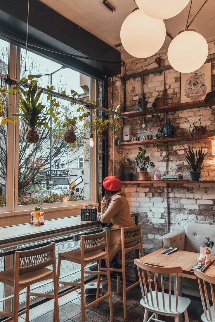 Cozy Urban Oasis: A Cafe Design Merging Exposed Brick, Nature, and Modern Elegance