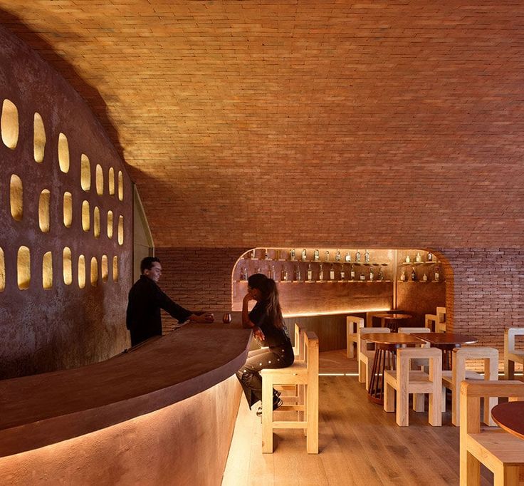 Cozy Cafe Design Blends Curved Brick, Warm Lighting, and Minimalist Elements for Inviting Ambiance