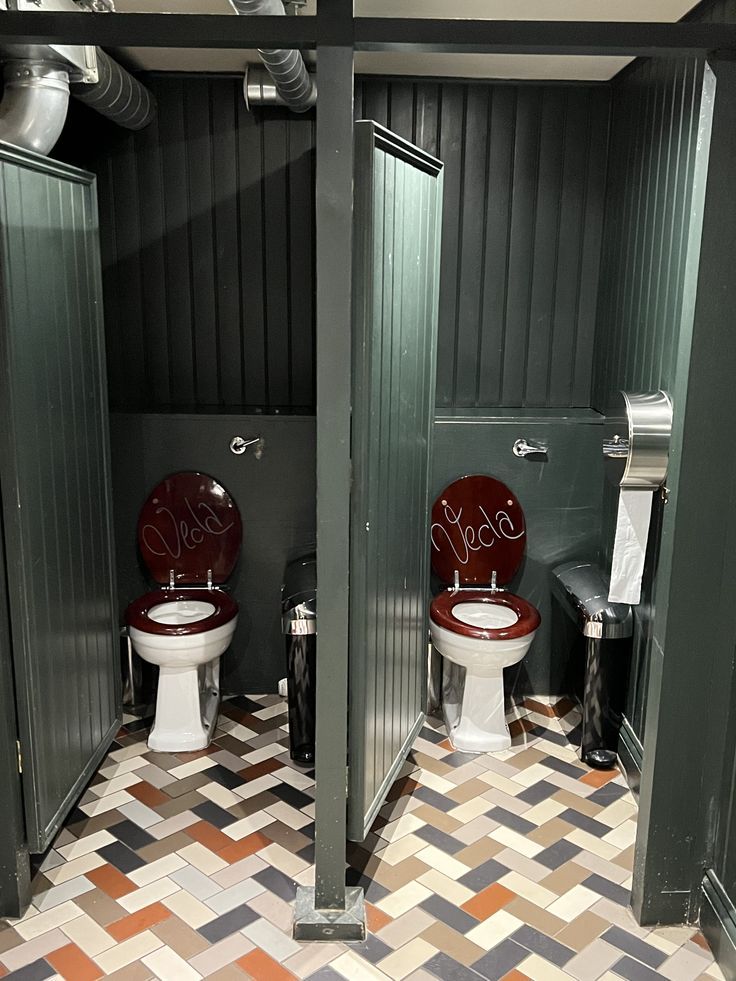 Stylish Urban Cafe Restroom Featuring Dark Green Walls, Maroon Seats, and Intricate Tile Flooring