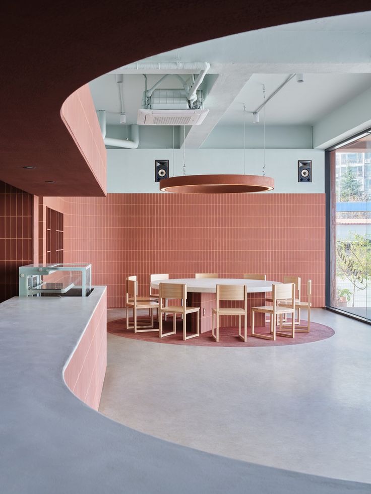 Modern Cafe Design: Inviting Aesthetics with Soft Pink Accents and Communal Spaces