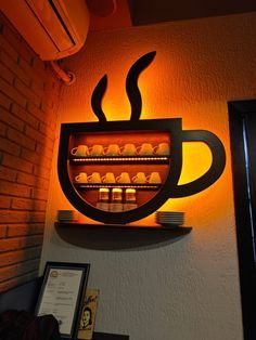 Cozy Cafe Design: Whimsical Coffee Cup Wall Display Enhanced by Warm Lighting and Textured Brick Backdrop