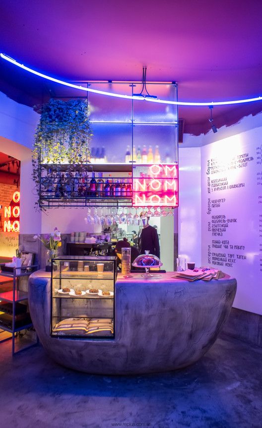 Contemporary Cafe Design: Playful Aesthetics with Neon Accents and Vertical Greenery