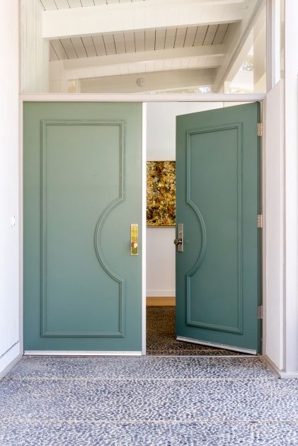 Inviting Entrance with Modern Green Double Doors and Bright, Open Cafe Interior