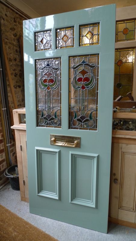 Charming Mint-Green Door with Stained Glass Panels Invites Patrons to a Cozy Cafe Atmosphere