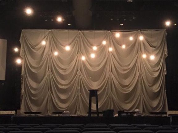 Elegant Stage Backdrop Inspires Cozy Cafe Design with Warm Drapery and Ambient Lighting