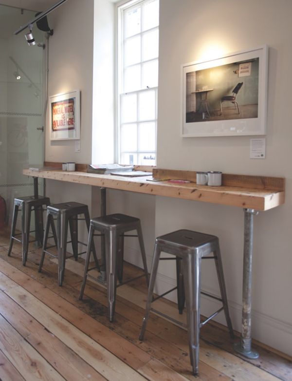 Minimalist Cafe Design: Inviting Atmosphere with Communal Wooden Counter and Industrial Touches