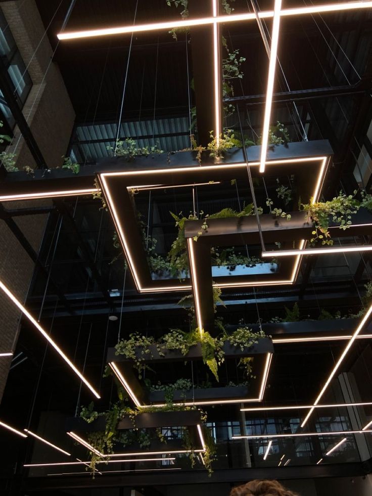 Striking Cafe Design Merges Modern Lighting with Lush Greenery for a Sophisticated Atmosphere