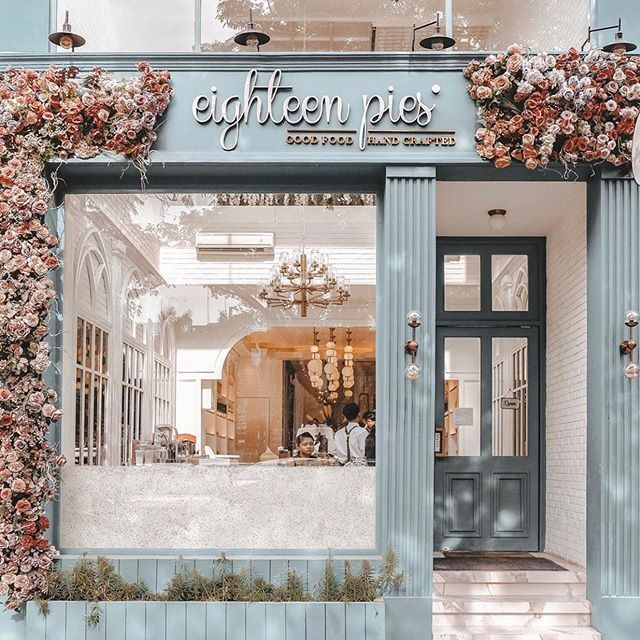 Charming Cafe with Pastel Blue Facade and Floral Decor Creates Inviting Space for Relaxation