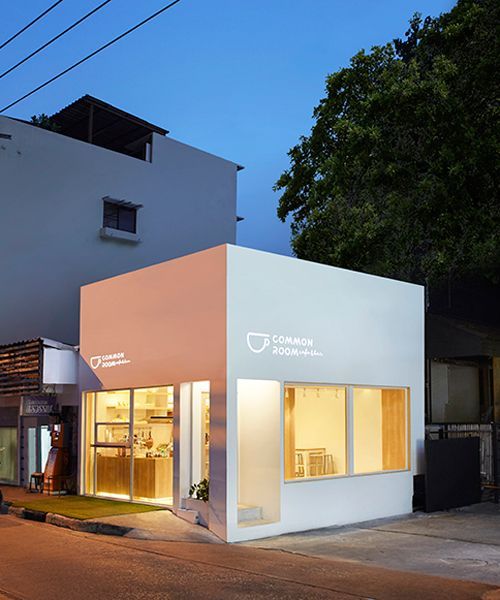 Modern Minimalist Cafe Design: Sleek White Exterior and Inviting Atmosphere with Natural Light and Greenery