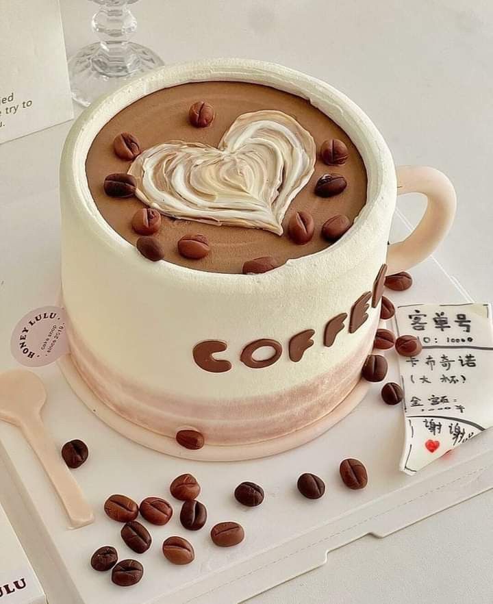 Whimsical Coffee Cup Cake Captures Cafe Ambiance with Heart-Shaped Icing and Realistic Coffee Beans