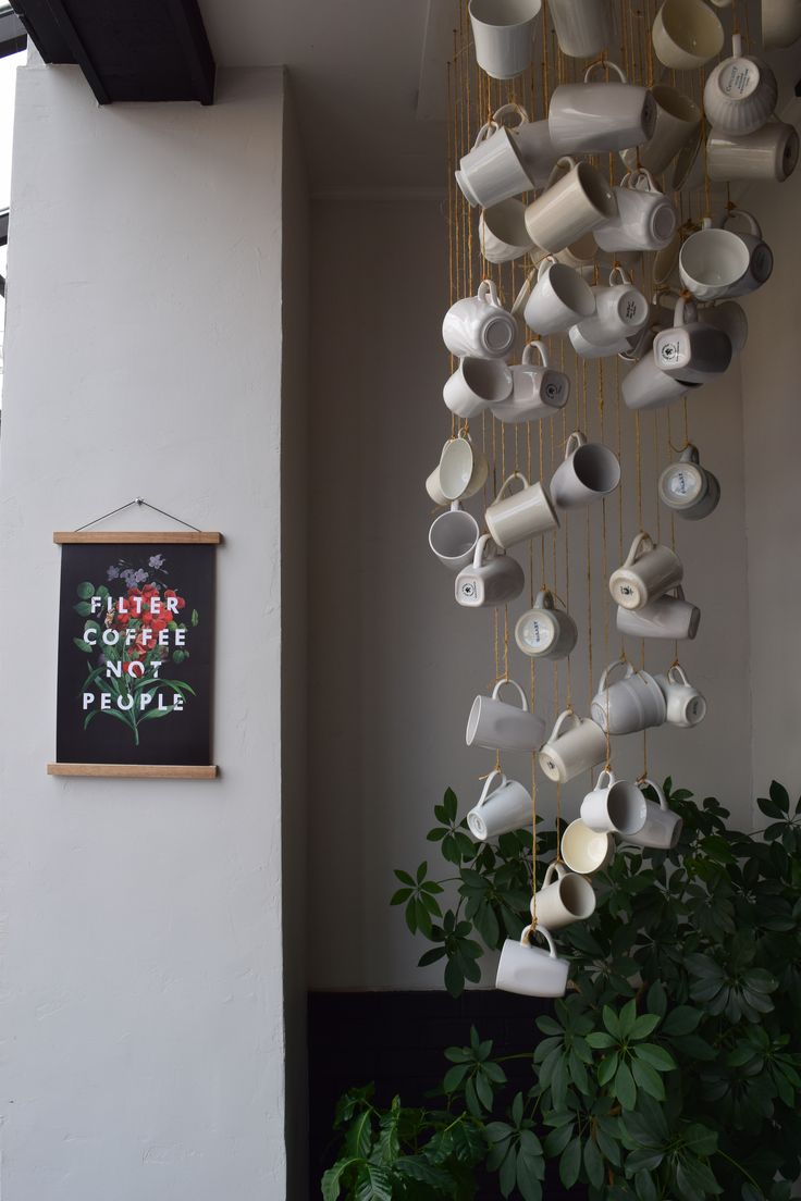 Modern Cozy Cafe Design: Artistic Hanging Cups and Lush Greenery Create an Inviting Atmosphere