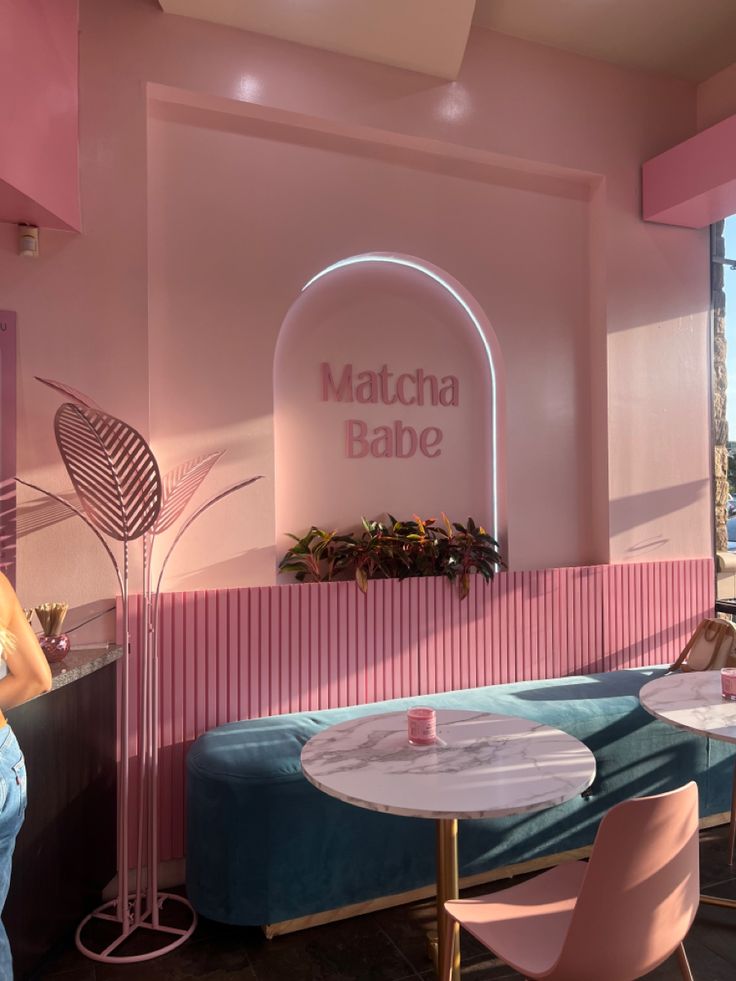 Modern Cafe Interior: Pastel Pink Hues, Lush Greenery, and Whimsical Accents Create a Vibrant Atmosphere