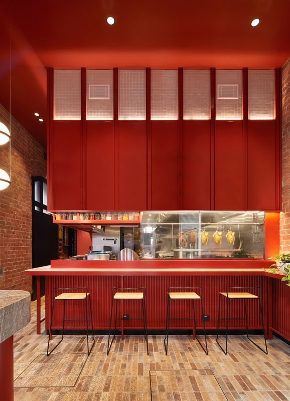 Modern Cafe Design Blends Warm Deep Red Hues with Industrial Charm for an Inviting Atmosphere