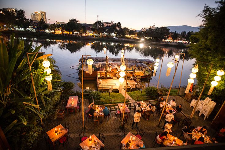 Charming Riverbank Cafe: A Serene Outdoor Dining Experience with Cozy Ambiance and Unique Design