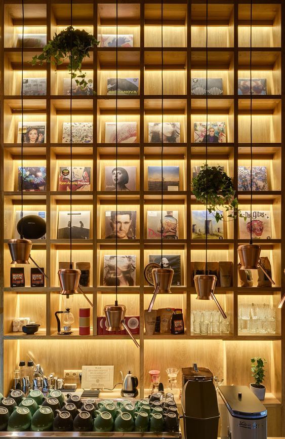 Inviting Cafe Design with Warm Wood Shelving, Modern Coffee Accessories, and Lush Greenery