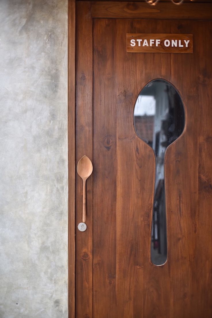 Inviting Cafe Door Design: A Creative Fusion of Wood, Playful Handle, and Modern Concrete