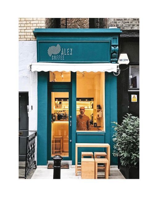 Charming Teal Cafe: A Welcoming Urban Oasis with Playful Awning and Cozy Vibe