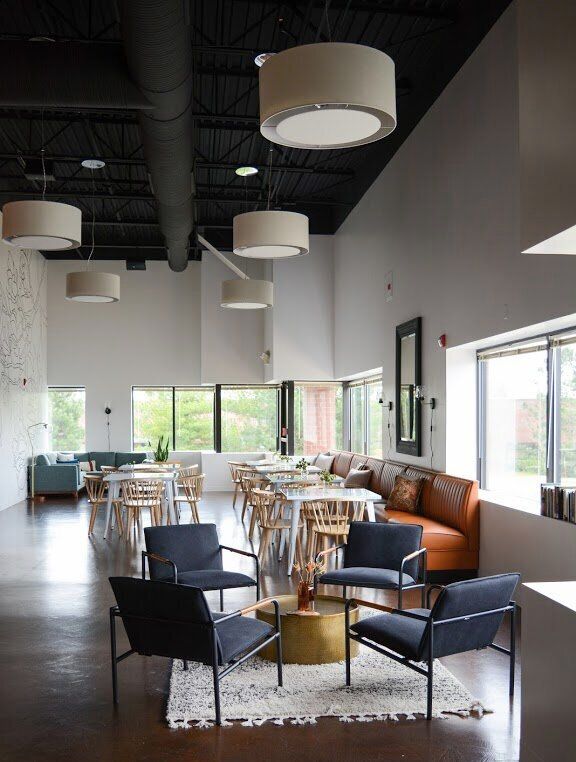 Modern Cafe Design: Spacious, Welcoming Aesthetic Enhanced by Natural Light and Varied Seating