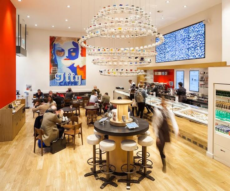 Modern Cafe Design: A Vibrant Space Featuring a Striking Red Accent Wall and Unique Chandelier