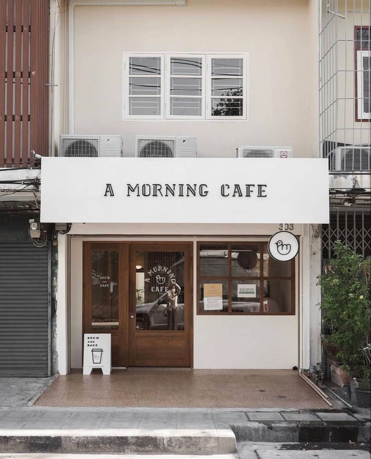 Modern Cafe Design: Minimalist Facade with Inviting Natural Light and Warm Accents