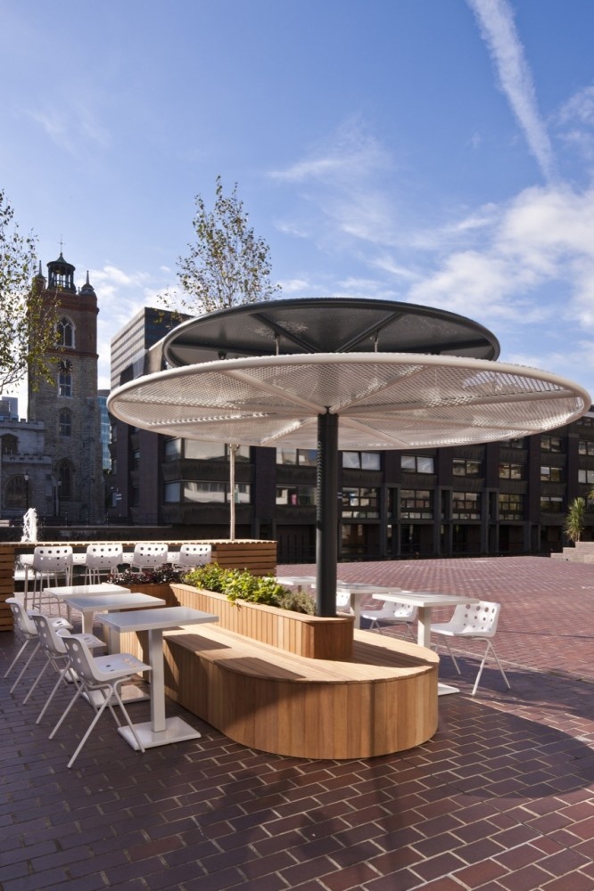 Modern Outdoor Cafe Design with Unique Canopy, Communal Seating, and Greenery in Urban Setting